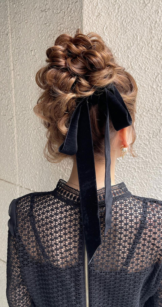A Trendy Collection of Hairstyles Adorned with Chic Bows : Messy Top Bun with Blue Bow