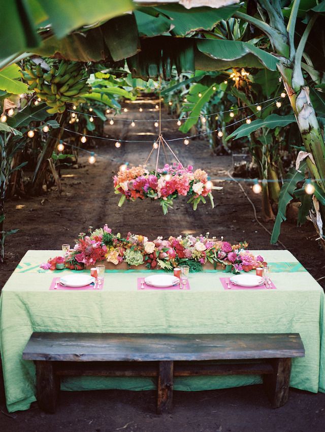 A colorful and tropical banana grove wedding photographed by Jonathan Canlas in Hawaii with a tropical flower chandelier.