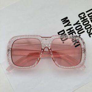 Trendy crystal star embossed on light pink sunglasses.