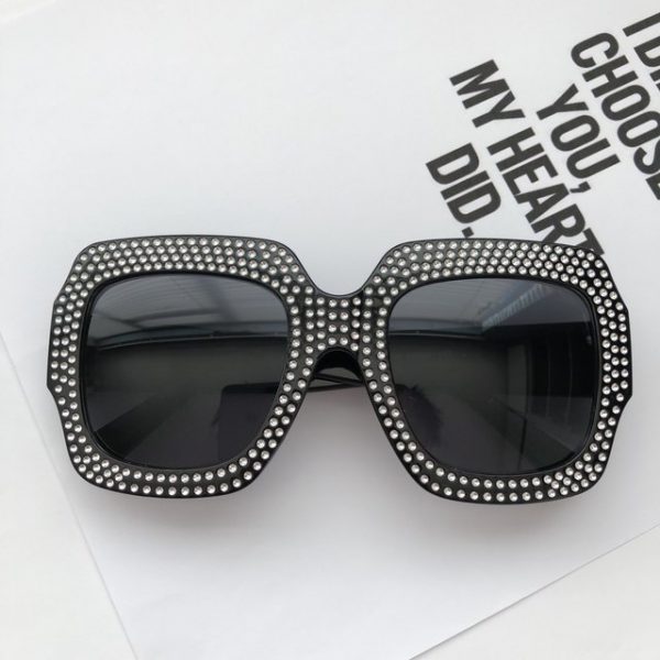 Trendy crystal embossed on black sunglasses with black tint.